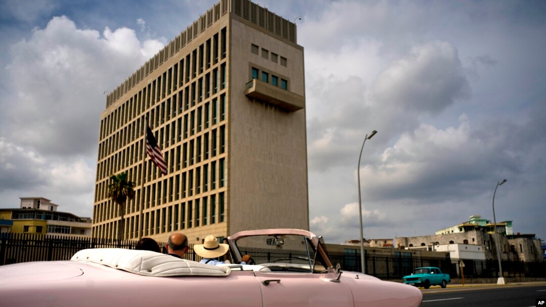 Tourists take a ride in a vintage car as they pass the U.S. embassy in Havana, Cuba, March 18, 2019. 