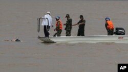 라오스 여객기 추락사고 현장에서 구조대원들이 시신 인양작업을 벌이고 있다. 