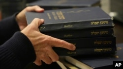 Craig Berko, director of membership at Temple Beth Sholom, prepares to hand out prayer books during a Shabbat service, Sept. 27, 2024, in Miami Beach, Fla.