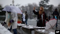 A visitor takes a picture in the historic Sultanahmet district in Istanbul, Jan. 18, 2016. Heavy snowfall has swept northwestern Turkey, grounding hundreds of flights, disrupting ground transport and closing schools in Istanbul.