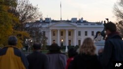 People gather outside the White House in Washington after the Secret Service arrested a man who was caught jumping the fence as President Barack Obama and his family ate Thanksgiving dinner, Nov. 26, 2015.