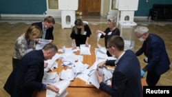 Members of a local election commission count ballots at a polling station inside Kazansky railway terminal after polls closed during a three-day long parliamentary election in Moscow, Russia, Sept. 19, 2021. 