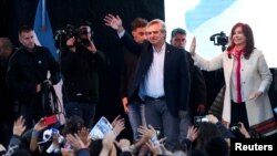 El candidato presidencial Alberto Fernández, de la Unidad Ciudadana, saluda a sus simpatizantes, junto a su candidata a vicepresidente , la expresidenta de Argentina, Cristina Fernández de Kirchner, durante un mitin en Merlo, Buenos Aires, Argentina, el 25 de mayo de 2019. 