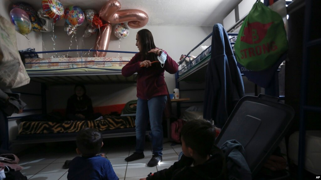 A migrant woman stands in a room at the San Matias shelter in Ciudad Juarez on February 9, 2022. Asylum seekers are forced to wait out their U.S. immigration cases in Mexico in shelters like San Matias. (AP Photo/Christian Chavez)