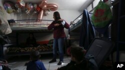 A migrant woman stands in a room at the San Matias shelter in Ciudad Juarez on February 9, 2022. Asylum seekers are forced to wait out their U.S. immigration cases in Mexico in shelters like San Matias. (AP Photo/Christian Chavez)