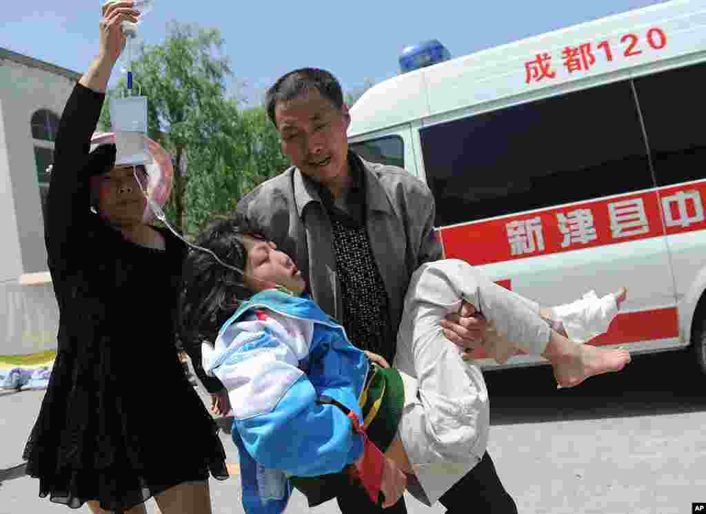 Seorang pria menggendong seorang wanita yang terluka ke pusat pengobatan sementara menyusul gempa bumi di desa Lushan, wilayah Ya&#39;an propinsi Sichuan, China, 20 April 2013.