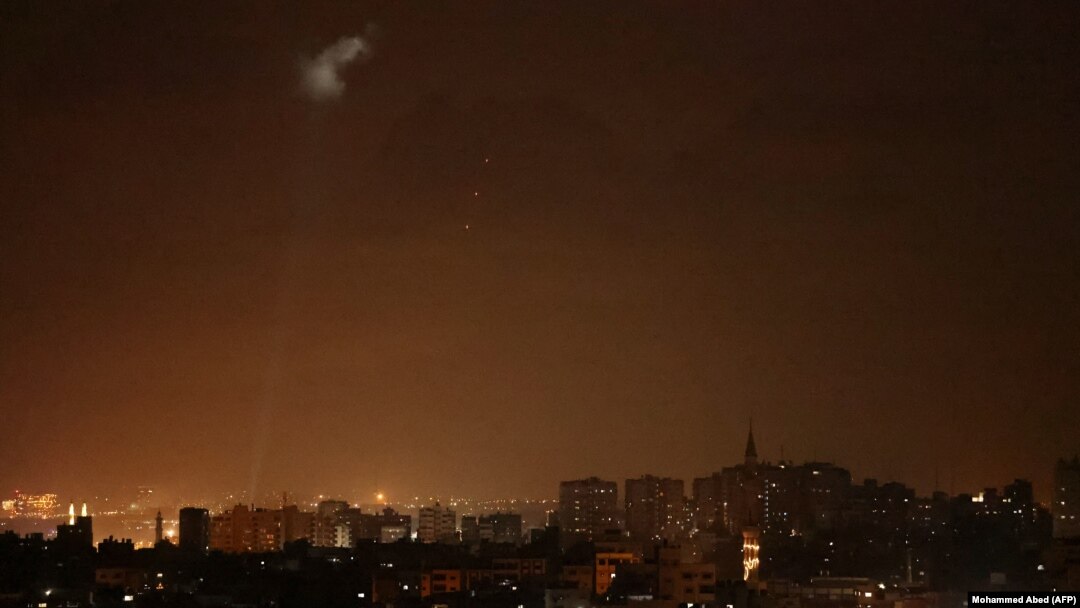 Tembakan-tembakan dari wilayah Palestina menerangi langit malam di Kota Gaza, Sabtu, 3 Juli 2021, untuk membalas serangan udara Israel. (Foto: Mohammed Abed/AFP)
