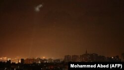 Tembakan-tembakan dari wilayah Palestina menerangi langit malam di Kota Gaza, Sabtu, 3 Juli 2021, untuk membalas serangan udara Israel. (Foto: Mohammed Abed/AFP)