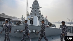 FILE - Sailors walk on the deck of the INS Imphal, a stealth guided-missile destroyer, at the Naval Dockyard in Mumbai, Dec. 22, 2023.