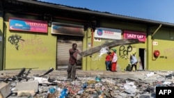 Inanda community members clean up after the Dube Village Mall in Durban was looted, July 17, 2021.