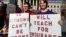 Teachers John and Kerry Guerini of Fayetteville, West Virginia, hold signs at a rally at the state Capitol in Charleston, W.Va., Feb. 26, 2018. 