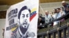 Familiares de presos políticos aplauden junto a una pancarta que representa al legislador detenido Juan Requesens durante la ceremonia de juramento de Juan Guaidó en el congreso de Caracas, Venezuela 5 de enero de 2019.
