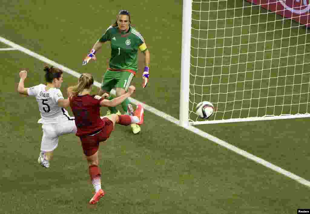 La défenseuse américaine Kelley O'Hara (5) marque contre la gardienne allemande Nadine Angerer (1) au cours de la deuxième moitié de la demi-finale de la Coupe du Monde/Dames 2015 de la FIFA au Stade olympique, le 30 juin 2015 à Montréal, Québec. Credit: 