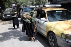 Taliban fighters search a vehicle at a checkpoint on a road in the Wazir Akbar Khan neighborhood in Kabul, Afghanistan, Aug. 22, 2021.