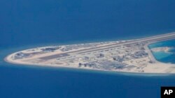 FILE - An airstrip, structures and buildings on China's man-made Subi Reef in the Spratly chain of islands in the South China Sea are seen from a Philippine Air Force C-130 transport plane, April 21, 2017. 