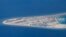 FILE - An airstrip, structures and buildings on China's man-made Subi Reef in the Spratly chain of islands in the South China Sea are seen from a Philippine Air Force C-130 transport plane, April 21, 2017. 