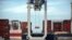 FILE - A ship-to-shore crane prepares to load a 40-foot shipping container onto a container ship at the Port of Savannah in Savannah, Georgia, July 5, 2018.