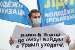 FILE - An activist of the Liberal Democratic Party of Russia holds a placard during a demonstration ahead of the U.S. presidential election, in front of the U.S. embassy in Moscow, Russia, Oct. 31, 2020.