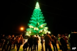 Syrian citizens gather outside Saydnaya Convent during the lighting of the Christmas tree, in Saydnaya town on the outskirts of Damascus, Syria, Dec. 24, 2024.