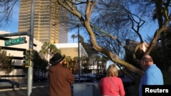 La gente se para frente a una cinta amarilla de cara a la Torre Trump, después de que un Tesla Cybertruck se incendiara en la entrada del edificio en Las Vegas, Nevada, EEUU, el 1 de enero de 2025.