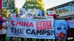 Uyghur and other demonstrators hold a banner and placards as they await the arrival of Chinese Premier Li Qiang in Adelaide, Australia, on June 16, 2024. Human rights groups said on June 20 that the U.N. must act on a two-year-old report of rights violations against the Uyghurs.