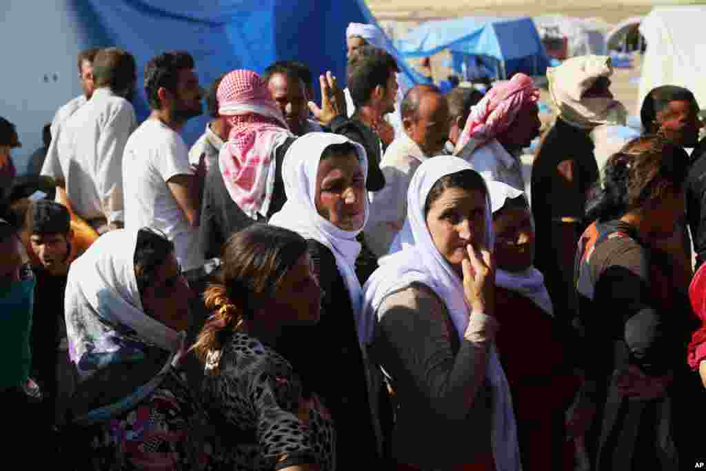 Displaced Iraqis from the Yazidi community gather for humanitarian aid at Nowruz camp, in Derike, Syria, Aug. 12, 2014.