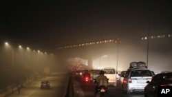 Commuters drive on a road engulfed in smog in New Delhi, India, Thursday, Nov. 5, 2020. 