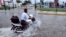 A man drives his motorcycle through a street flooded by rain brought by Hurricane Raymond in Acapulco, Oct. 21, 2013.