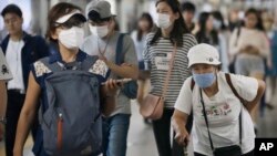 Passengers wearing masks as a precaution against the MERS virus make their way after they got off a train at a subway station in Seoul, South Korea, June 18, 2015.