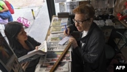 Una mujer compra un periódico en un quiosco en Caracas, Venezuela, en julio de 2019. La oferta actual de diarios impresos es poca en la capital y nula en regiones como Zulia, en el occidente del país.