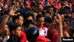 Supporters surround Jakarta governor and presidential candidate Joko Widodo (C) during a PDI-P party campaign in Cilegon, Banten province, March 28, 2014.