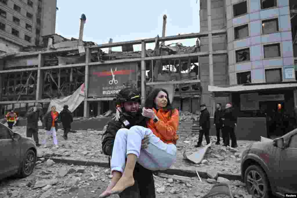 A police officer evacuates a woman from a building heavily damaged by a Russian missile strike in Zaporizhzhia, Ukraine. REUTERS/Stringer