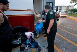 Red Cross, Indian River County EMS and Indian River Sheriff personnel assist an evacuee at the Vero Beach High School Freshman Learning Center, in advance of the potential arrival of Hurricane Dorian, in Vero Beach, Fla., Monday, Sept. 2, 2019.