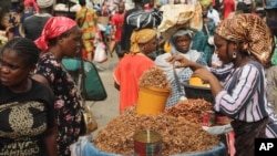 FILE - A woman sells crayfish at a market in Lagos, Nigeria, Feb. 16, 2024. With the West African nation beset by economic challenges, many are turning to a traditional community savings arrangement known as Ajo.