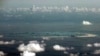 FILE - An aerial photo taken May 11, 2015 through a glass window of a military plane shows China's alleged on-going reclamation of Mischief Reef in the Spratly Islands in the South China Sea. 