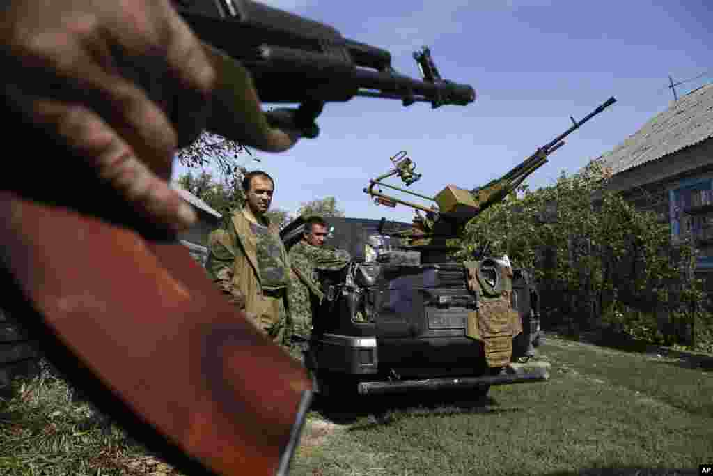 Pro-Russian rebels stand next to their car with a heavy machine gun in Donetsk, eastern Ukraine, Sept. 7, 2014.