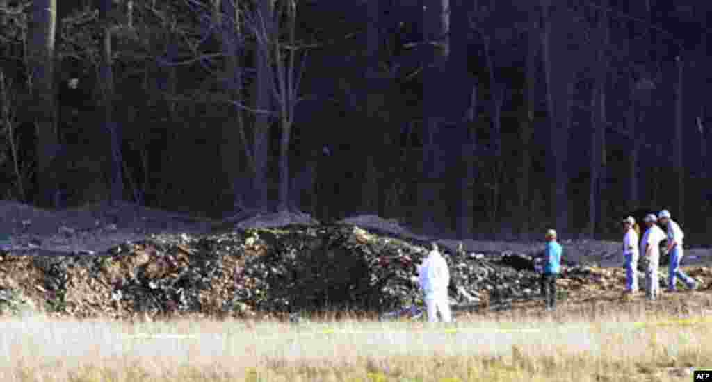 Emergency workers look at the crater created when United Airlines Flight 93 crashed near Shanksville, Pa., on Tuesday, Sept. 11, 2001. Radar showed the San Francisco-bound Boeing 757 from Newark, N.J., had nearly reached Cleveland when it made a sharp lef