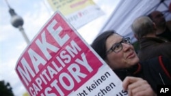 A protester holds a poster during a trade union demonstration against budget cuts, in Berlin, 29 Sept. 2010