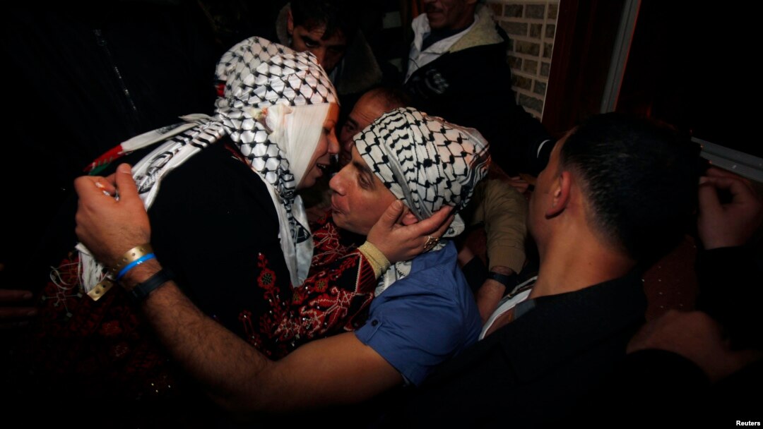Warga Palestina Rami Barbakh, yang ditahan Israel selama 20 tahun, memeluk ibunya setiba di Khan Younis, Jalur Gaza setelah dibebaskan Israel Selasa (31/12). 
