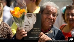 Un admirador del Gabo sostiene un ejemplar de la biografía del escritor y una flor amarilla frente al Palacio de Bellas Artes.