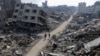 Palestinians walk past destroyed houses, amid the ongoing conflict between Israel and Hamas, in Jabalia refugee camp, in the northern Gaza Strip, Feb. 22, 2024. 