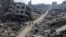Palestinians walk past destroyed houses, amid the ongoing conflict between Israel and Hamas, in Jabalia refugee camp, in the northern Gaza Strip, Feb. 22, 2024. 
