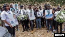 Mourners hold pictures of people killed in an armed gang attack on August 23 during their funeral service, in Kenscoff, Haiti, September 2, 2026. REUTERS/Patrice Noel