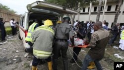 A victim of a bomb blast ripped through the United Nations offices in the Nigerian capital of Abuja is loaded into an ambulance, after a car rammed into the building, and witnesses said they had seen a number of dead bodies being carried from the site.