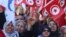 People wave national flags during demonstrations on the seventh anniversary of the toppling of president Zine El-Abidine Ben Ali, in Tunis, Jan. 14, 2018.