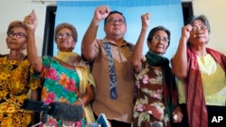 Four of the remaining 32 alleged WWII sex slaves clench their fists along with their legal counsel Harry Roque (c) to demand compensation and apology from the Japanese Government during a news conference in Manila, Philippines, Jan. 6, 2016. 