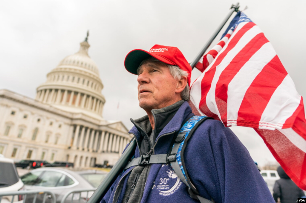 Lloyd Watkins de Nashville, Tennessee, un partidario del presidente Donald Trump lleva una bandera fuera del Capitolio, el 5 de enero de 2021.