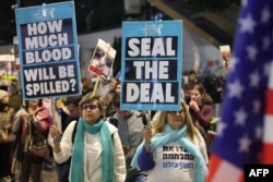 Demonstrators raise placards during a protest calling for action to secure the release of Israelis held hostage in Gaza since October 2023, in front of the Israeli Defense Ministry in Tel Aviv on Jan. 14, 2025.