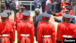 Kenya's outgoing President Mwai Kibaki inspects the honor guard before the official swearing-in ceremony of President Uhuru Kenyatta at Kasarani Stadium, Nairobi, April 9, 2013. 