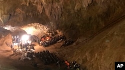FILE - Rescue teams gather as they search for a soccer team and their coach missing in a large cave in Mae Sai, Chiang Rai province, Thailand, June 26, 2018. Petty Officer 1st Class Bayroot Pakbara, died of an infection he contracted in the rescue.